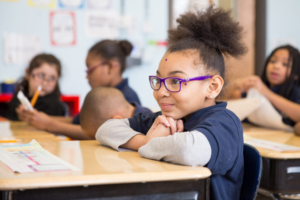 Elementary student listening attentively in a charter school classroom