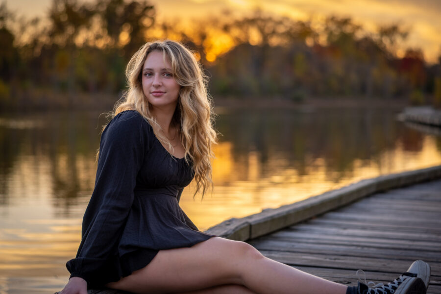 Senior portrait at sunset on a dock by the water in Carmel, Indiana