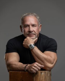 Men's headshot with hand on chin, black t-shirt, gray backdrop, LV Portrait Design studio in Carmel, Indiana